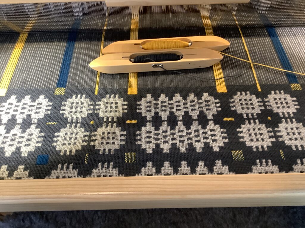 A traditional "Caernarfon" pattern Welsh blanket being woven on a loom.