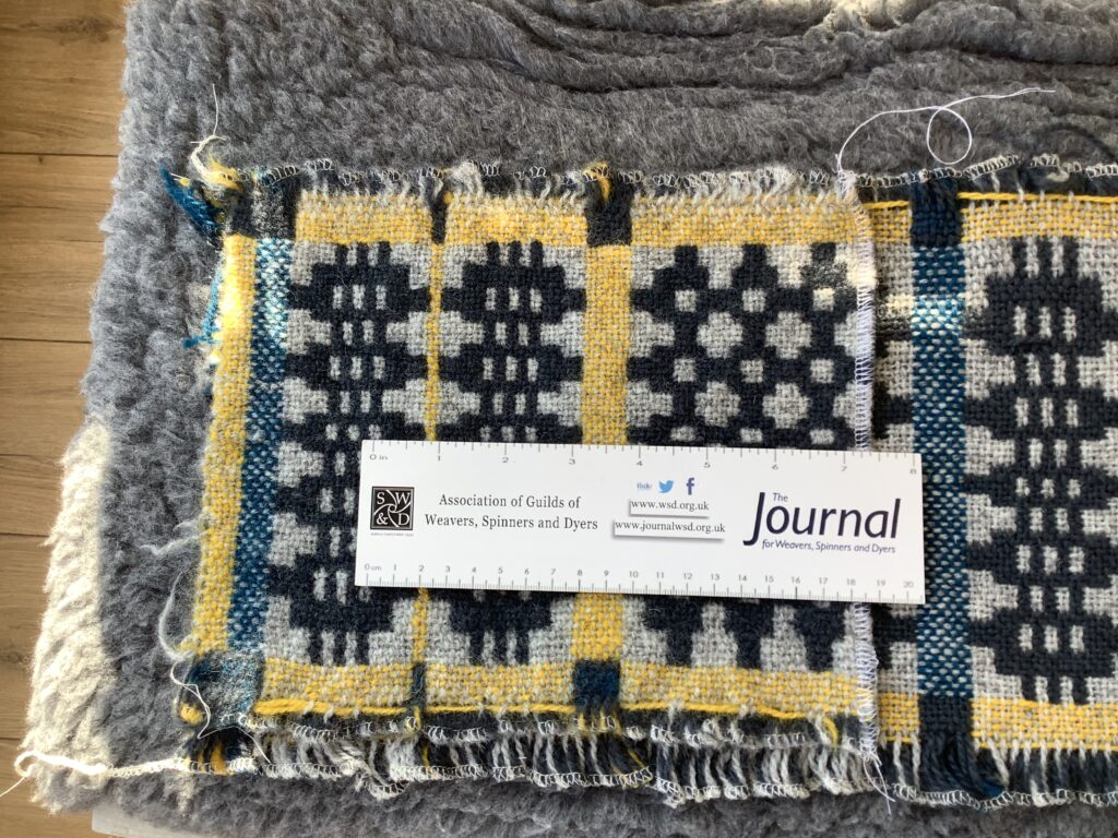 Samples of the Welsh blanket, with a ruler on top for scale.