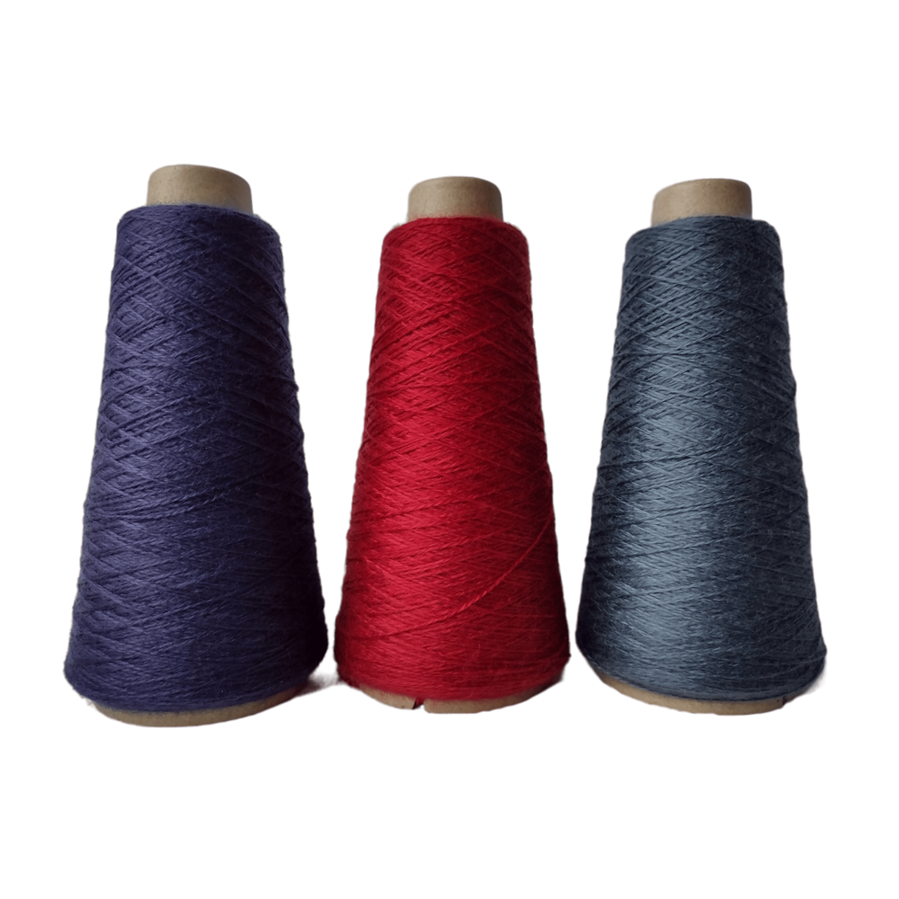 A group of three cones of Valley Yarns Merino-Tencel (TM) weaving yarn on a white background.