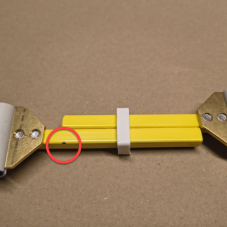 The bright yellow weaving stretcher has a small paint chip, circled in red.