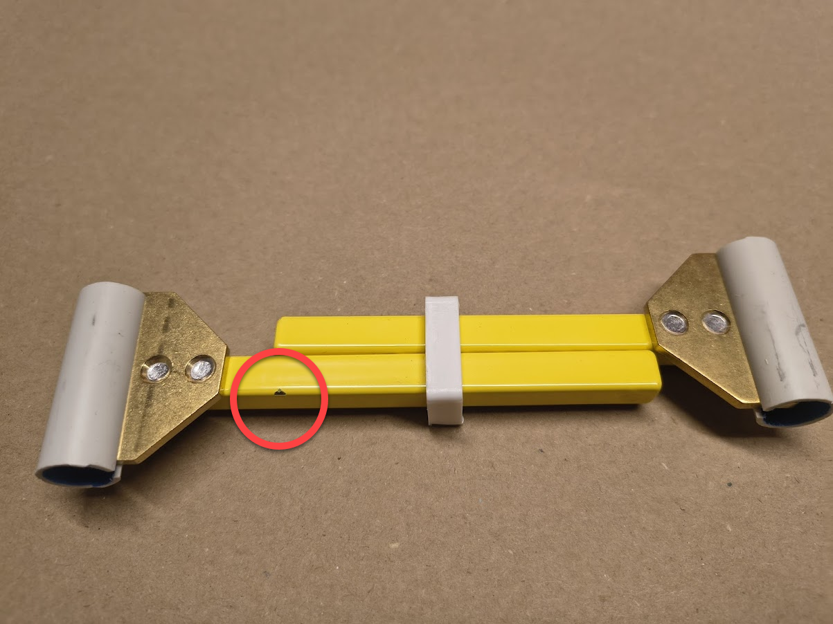 Toika Metal Stretcher 15-20cm (Small Yellow) – Second The bright yellow weaving stretcher has a small paint chip, circled in red.